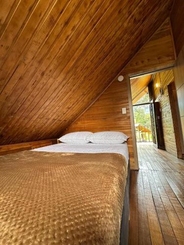 a large bed in a room with a wooden ceiling at Country house in Neusa in Cogua