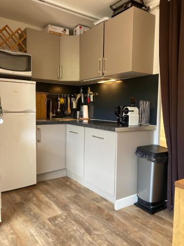 une cuisine avec des armoires blanches et un comptoir dans l'établissement Chez papi fernand la villetta, à La Plagne Tarentaise