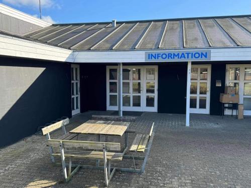 a building with a table and benches in front of it at 4 person holiday home in Hampen in Hampen