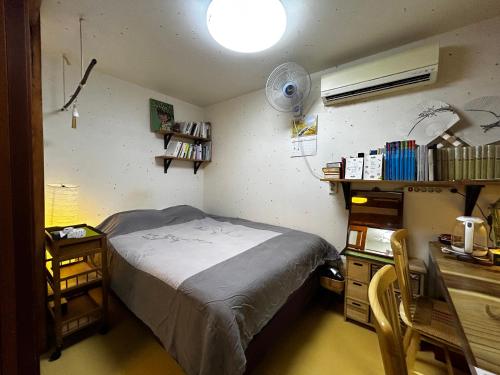 ソウルにあるEugene Hanok Stayのベッドルーム1室(ベッド1台、デスク、ファン付)