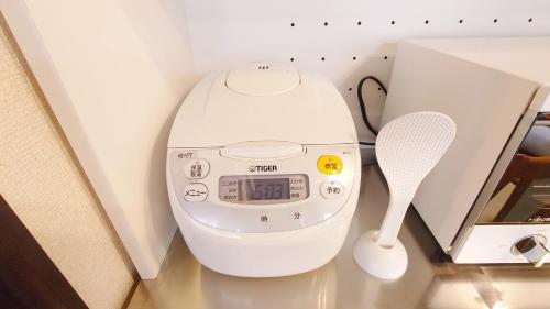 a white scale sitting next to a measuring instrument at 名鉄名古屋まで7分1棟貸し切り駐車場あり in Nishi-biwashima