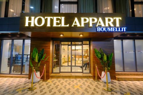 a hotel apartment building with plants in front of it at Hôtel Appart Boumellit Centre Ville Jijel in Jijel