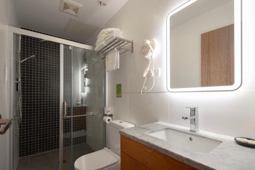 a bathroom with a sink and a toilet and a mirror at YEHS Hotel Sydney QVB in Sydney