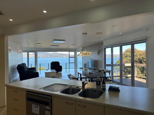 a kitchen with a sink and a view of the ocean at Rotorua Luxury lakeside Resort in Rotorua