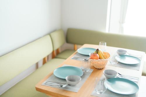 a table with blue plates and a basket of fruit at Restelle - JR Nara 2min Max 7 guests in Nara
