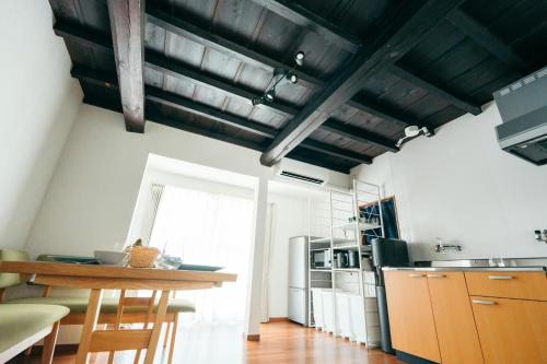 a kitchen with white walls and wooden ceilings and a wooden table at Restelle - JR Nara 2min Max 7 guests in Nara