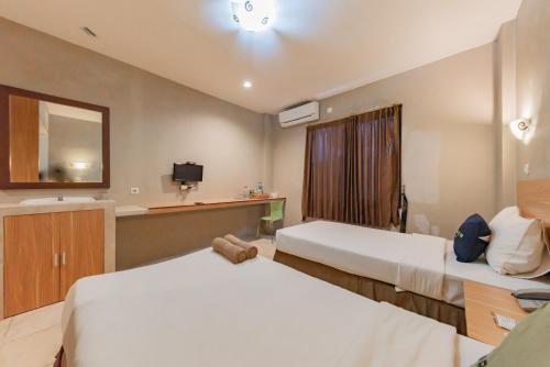 Postel nebo postele na pokoji v ubytování RedDoorz Plus at Hotel Ulin Samarinda