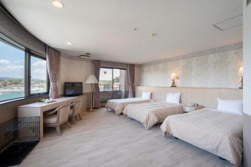a hotel room with two beds and a desk at Izumigo Lake Hamana Dog Paradise Hotel in Hamamatsu