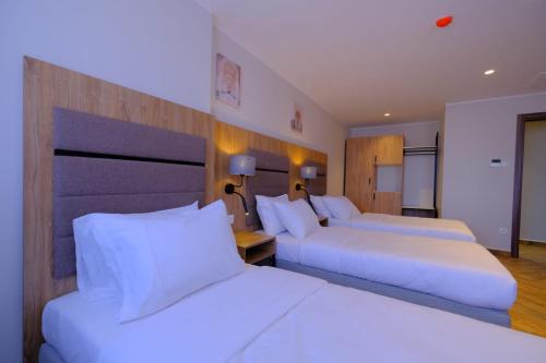 two beds in a hotel room with white pillows at Hôtel Appart Boumellit Centre Ville Jijel in Jijel