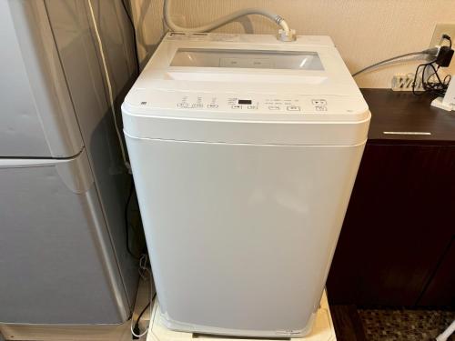 a white washer and dryer sitting next to a refrigerator at 板橋 RCアネックス Rc308 in Tokyo