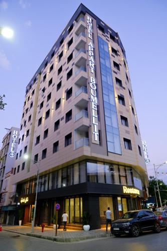 a large building with a car parked in front of it at Hôtel Appart Boumellit Centre Ville Jijel in Jijel