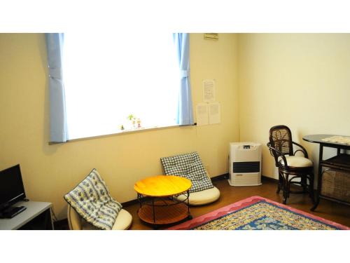 a living room with a table and chairs at Petit Hotel Koizumi - Vacation STAY 85672v in Lake Toya