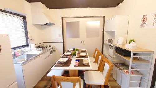 a small kitchen with a table with chairs and a sink at 名鉄名古屋まで7分1棟貸し切り駐車場あり in Nishi-biwashima