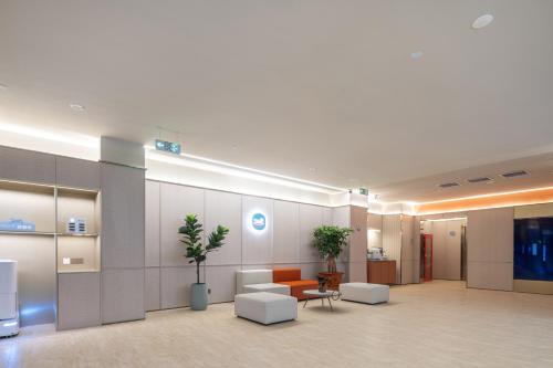 an office lobby with a waiting area with couches and chairs at Hanting Hotel Beijing Rocket Wanyuan Subway Station in Beijing