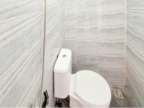 a bathroom with a white toilet in a stall at Dahayu House Kaliurang Yogyakarta RedPartner in Ngemplak