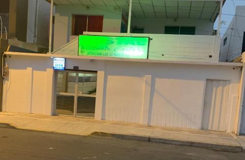 a store with a sign on the side of a building at Hostal Montecarlos in Salinas