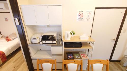 a room with two chairs and a desk and a bed at 名鉄名古屋まで7分1棟貸し切り駐車場あり in Nishi-biwashima