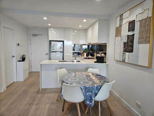 a kitchen and dining room with a table and chairs at Glen Oasis - Luxury Apartment in Glen Waverley