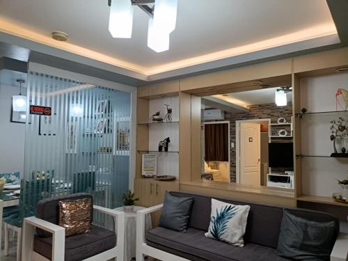 a living room with a couch and a mirror at One Oasis 2br Condo in Davao City