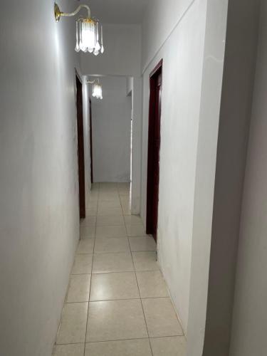 a hallway with white walls and a light fixture at Hostal Montecarlos in Salinas