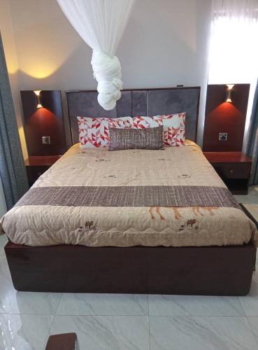 a bedroom with a large bed with red and white pillows at Aquifers Executive Bed and Breakfast in Lilongwe