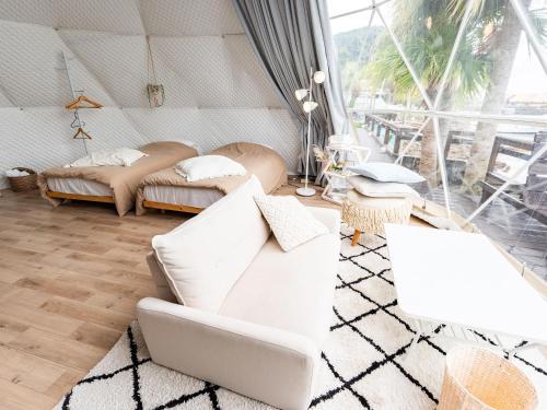 a living room with a white couch and two beds at Calm Lanai Harbor in Nichinan