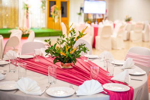 a table with a pink table cloth and white chairs at Tanoa Waterfront Hotel in Lautoka