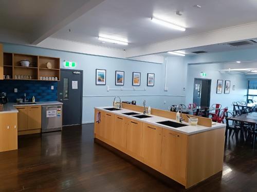 a kitchen with blue walls and a counter with sinks at Urbanz in Christchurch