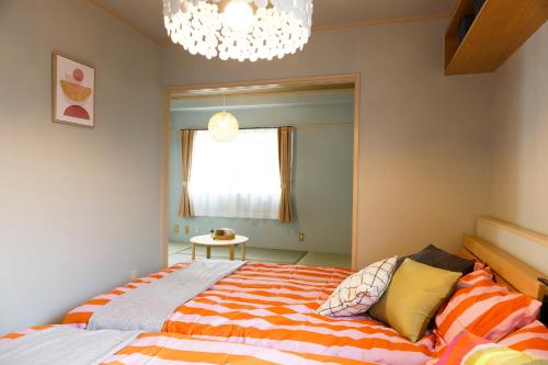 a bedroom with a large bed and a chandelier at GS42 名古屋栄Area食卓あり和洋ルーム観光家族旅行ビジネスに最適 in Nagoya