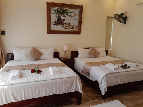 two beds in a hotel room with flowers on them at Lys Homestay in Ninh Binh