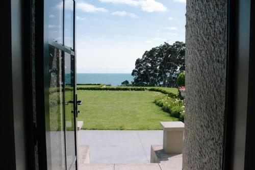 a door to a yard with a view of the ocean at Bay View Terrace Studio 4 in Tataraimaka