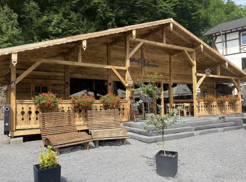 a building with benches and flowers in front of it at Landhotel Ringelsteiner Mühle in Moselkern
