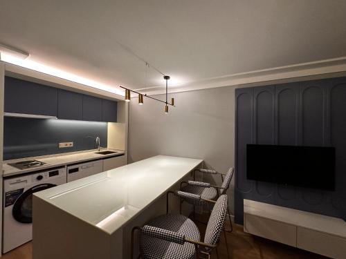 a kitchen with a counter with chairs and a tv at OTTO Tunalı Houses in Ankara