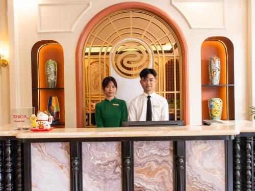a man and a woman standing behind a counter at San Hotel & Spa in Hanoi