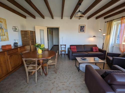 un salon avec un canapé et une table dans l'établissement Maison avec grand jardin clos et équipements bébé - FR-1-653-22, à Cellefrouin