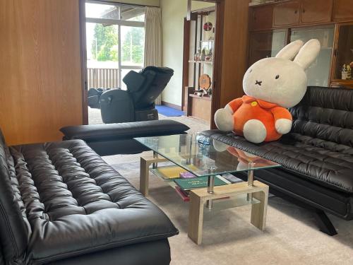 a living room with a stuffed rabbit sitting on a couch at 農家民泊うまころ in Oshu