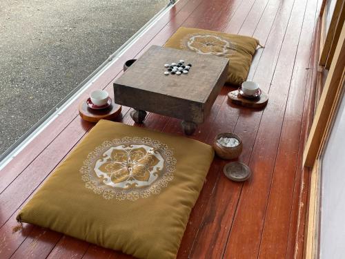 a wooden deck with cushions and a table andcoins at 農家民泊うまころ in Oshu