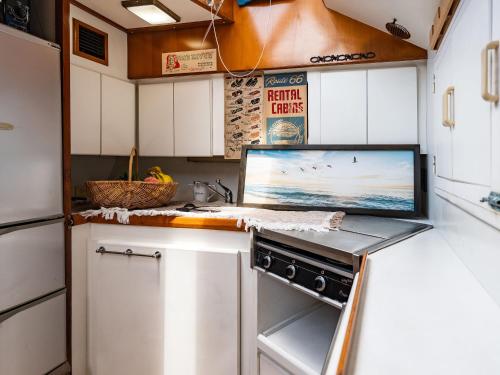 a kitchen with white cabinets and a counter top at Calm Lanai Harbor in Nichinan