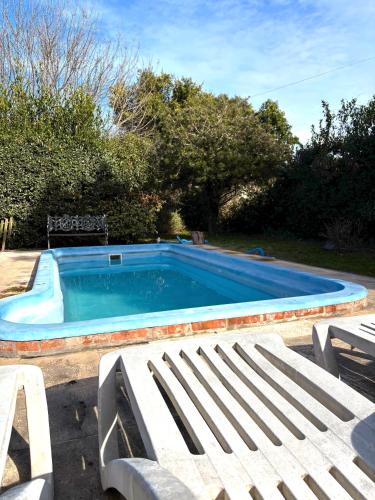 a large swimming pool with a bench and aitating at Mini cabaña El Solcito, tranquilidad a dos cuadras de la Laguna de Chascomús in Chascomús