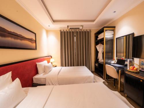 a hotel room with two beds and a desk at San Hotel & Spa in Hanoi