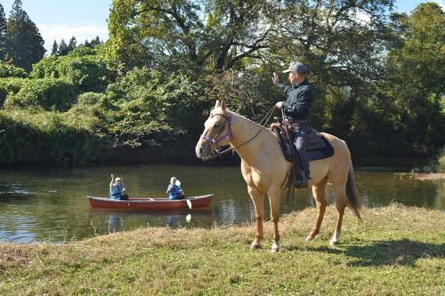 a man sitting on a horse next to a boat at 農家民泊うまころ in Oshu