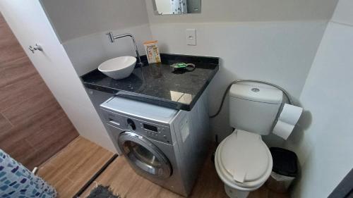 a bathroom with a sink and a washing machine at Apartamento Cambui - Centro de Convivência in Campinas