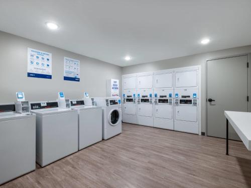 a laundry room with white washers and dryers at ECHO Suites Extended Stay by Wyndham Fort Worth Alliance in Fort Worth