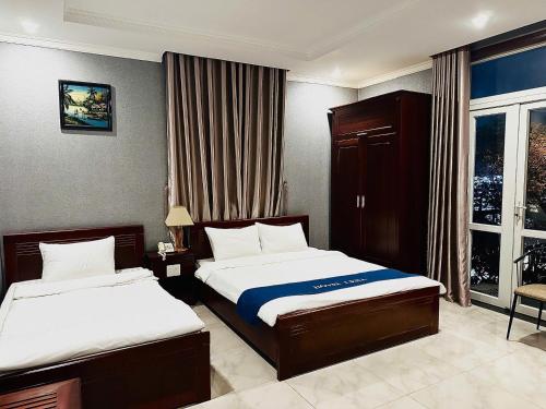 a hotel room with two beds and a window at LENA HOTEL in Danang