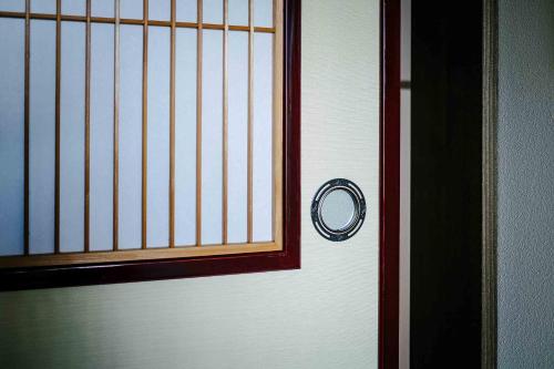 a door with a window and a handle on it at Nananohi Machiya House in Takayama