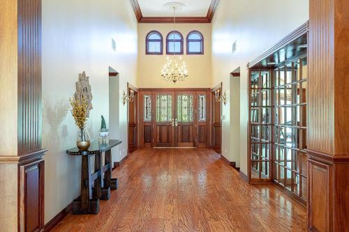 a large hallway with wooden floors and a chandelier at The Oaktree Estate by Fieldtrip 7 Acre Private Resort with Lake Pool Vineyard in Lake Elsinore