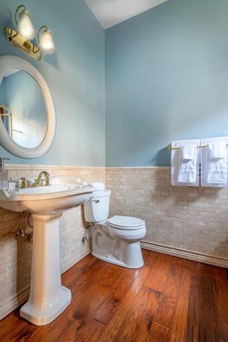 a bathroom with a sink and a toilet and a mirror at The Oaktree Estate by Fieldtrip 7 Acre Private Resort with Lake Pool Vineyard in Lake Elsinore
