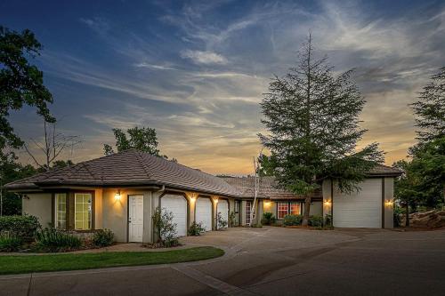 a house with a garage and a tree at The Oaktree Estate by Fieldtrip 7 Acre Private Resort with Lake Pool Vineyard in Lake Elsinore