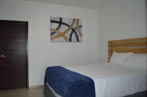 um quarto com uma cama e uma pintura na parede em Room 7 Ciudad Jardin em San Miguel
