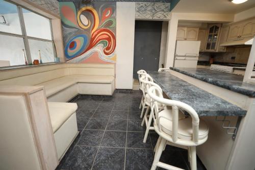 a kitchen with a counter and chairs in a room at Xio's House in Manuel F. Martínez